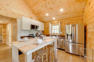 a kitchen with a large island and a refrigerator at Hike, Ski and Explore Bigfork Cabin with Mtn Views! in Finley Point
