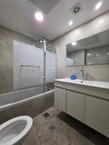 a bathroom with a toilet and a sink and a shower at Hantke22• Horev Penthouse • Jacuzzi • 4BD in Aẖuzzat Shemu‘el