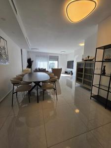 a dining room with a table and chairs in a room at Hantke22• Horev Penthouse • Jacuzzi • 4BD in Aẖuzzat Shemu‘el