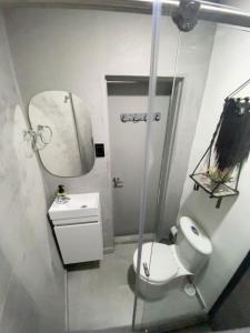 a bathroom with a toilet and a sink and a mirror at Espectacular apartaestudio en envigado cerca de todo in Envigado