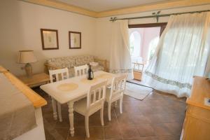a room with a table and chairs and a couch at Beautiful Giardino Degli Oleandri-1BedApt BILO4 in Liscia di Vacca
