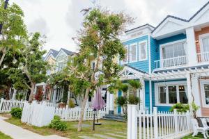 a blue house with a white fence at Coral Sunset Villa in Bình Tú
