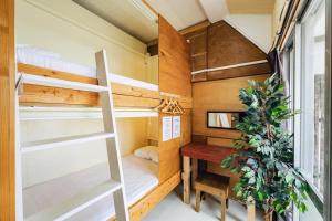 a tiny house with a desk and bunk beds at 全室個室のゲストハウス オプンティア Guesthouse Opuntia in Ishigaki Island