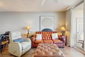 una sala de estar con un sofá y una silla en The Beach Club 1007C, en Gulf Shores