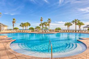 Una gran piscina con palmeras al fondo. en The Beach Club 1007C, en Gulf Shores
