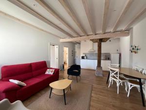 a living room with a red couch and a table at Otero de Campoo Apartamentos in Espinilla