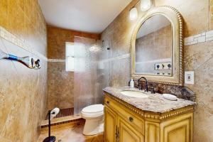 Un baño con lavabo, inodoro y espejo. en Mesquite House Upstairs Unit, en South Padre Island 16 fotos más