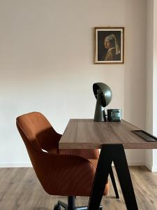 a desk with a chair and a picture on the wall at Studios et Appartement meublé de tourisme in Altkirch