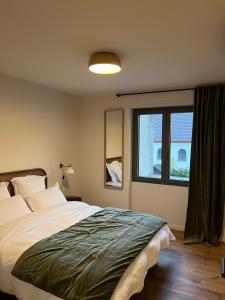 a bedroom with a large bed and a window at Studios et Appartement meublé de tourisme in Altkirch