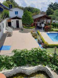 un jardín frente a una casa con piscina en Casa Campestre VILLA LOLITA, en Rozo