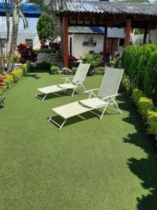 dos sillones sentados en el césped en un patio en Casa Campestre VILLA LOLITA, en Rozo