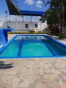 Una piscina con agua azul en un patio. en Casa Campestre VILLA LOLITA, en Rozo
