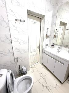 a white bathroom with a toilet and a sink at жилой компекс Флоренция in Bishkek