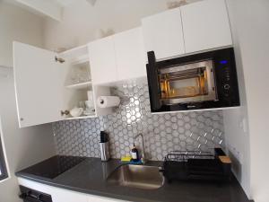 グランド・アンスにあるAtrium Apartments - Sorrel Loftのシンクと電子レンジ付きのキッチン