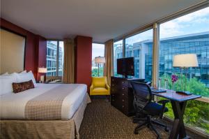 Habitación de hotel con cama y escritorio con TV. en Beacon Hotel & Corporate Quarters, en Washington