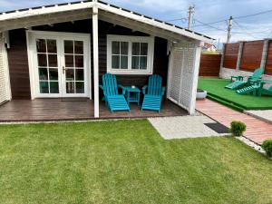 2 chaises bleues et une table sur une terrasse dans l'établissement Mika Tiny House, à Daia