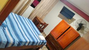 a bedroom with a bed and a dresser and a fan at Hospedaje El Sureño in Satipo