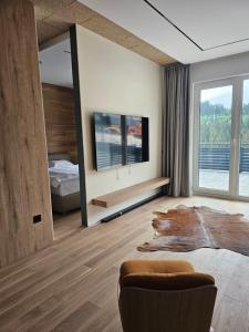 a bedroom with a bed and a tv in it at Apartman A 07 u sklopu hotela Vučko in Jahorina
