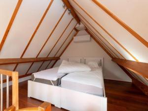 a bedroom with a white bed in the attic at Nieuwendamme 108 in Nieuwpoort +12 photos