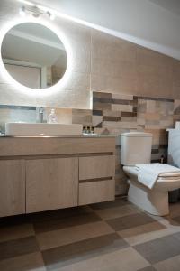 a bathroom with a sink and a toilet and a mirror at Nafplio Getaway Rooftop Terrace with unobstructed views of Palamidi Castle Fortress! in Nafplio +111 photos