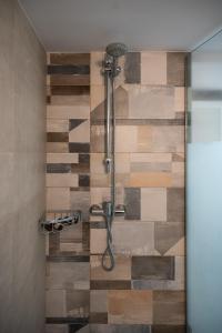 a shower in a bathroom with a wooden wall at Nafplio Getaway Rooftop Terrace with unobstructed views of Palamidi Castle Fortress! in Nafplio