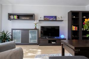 a living room with a flat screen tv and a table at Apartament Przy Wiślańskim Bulwarze - Wisła in Wisła
