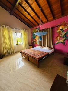 a bedroom with a bed with a painting on the wall at The Coconut tree villa in Dharga Town