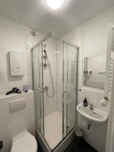 a bathroom with a shower and a toilet and a sink at Gemütliches City-Apartment in Top-Lage Hannover in Hannover