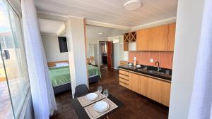 a room with a kitchen and a bedroom with a bed at Pousada Casa Silva in Maceió