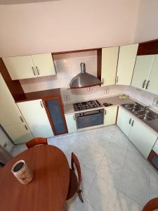 a kitchen with a table and a stove and a sink at Terrazza sul Mare Appartamenti in Marina di Camerota +1 photo