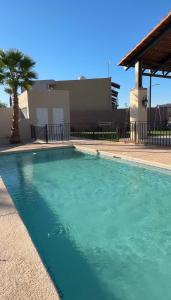 Una piscina con agua azul frente a un edificio. en Casa Victoria Totalmente Nueva, en Hermosillo