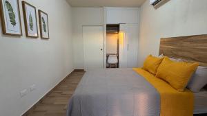 Un dormitorio con una cama grande con almohadas amarillas. en Casa Victoria Totalmente Nueva, en Hermosillo 42 fotos más