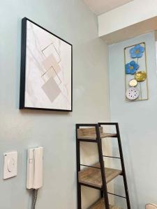 une étagère dans une pièce avec une photo sur le mur dans l'établissement Lanzon Azure Urban Resort Staycation, à Manille 2 autres photos