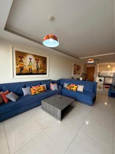 a living room with a blue couch and a table at Élégance et Sérénité Vue Mer Panoramique et Piscine Privée in Agadir