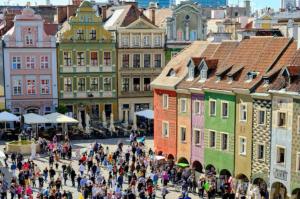 a crowd of people walking in a city with buildings at Oysters & Bubbles Gastro Rooms Rynek Square in Poznań