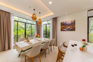 a dining room with a white table and chairs at Blue Sea villa in Cam Lâm