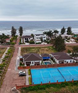 an aerial view of a resort with a tennis court and the ocean at Casa Grace Olón in Olón