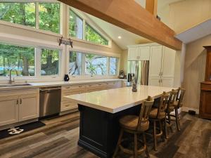 a kitchen with white cabinets and a large island with bar stools at Olga's Bay Lake House in Minett