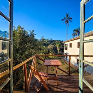 a wooden balcony with a table and a chair at EcoviLab in Guaratinguetá