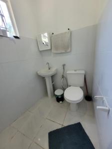 a white bathroom with a toilet and a sink at EcoviLab in Guaratinguetá