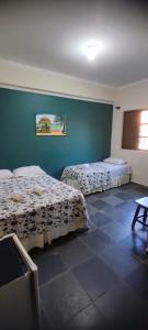 a bedroom with two beds and a blue wall at Pousada Tropical Vereda in Olímpia +68 photos