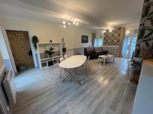 a living room with a table and a couch at Appartement chaleureux aux portes de Navarrenx - Fibre in Susmiou +3 photos