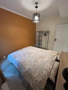 a bedroom with a bed with a white comforter at Appartement chaleureux aux portes de Navarrenx - Fibre in Susmiou
