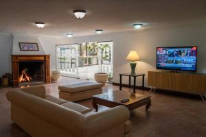a living room with a fireplace and a tv at Golden Beach Resort & Spa in Punta del Este