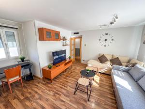 een woonkamer met een bank en een klok aan de muur bij Cineasta del Pilar - Turistea in Zaragoza