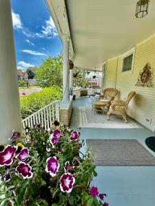 a porch of a house with purple flowers at The Rest Is History in Baraboo