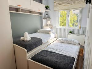 twee bedden in een kleine slaapkamer met een raam bij Cineasta del Pilar - Turistea in Zaragoza