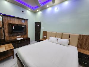 una camera da letto con un letto grande e una TV di Saha Guest House & Restaurant a Krishnanagar