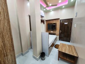 una camera da letto con un letto e un tavolo in una stanza di Saha Guest House & Restaurant a Krishnanagar