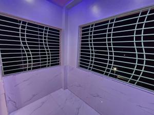 una stanza con due grandi finestre e un pavimento in marmo di Saha Guest House & Restaurant a Krishnanagar Altre 50 foto